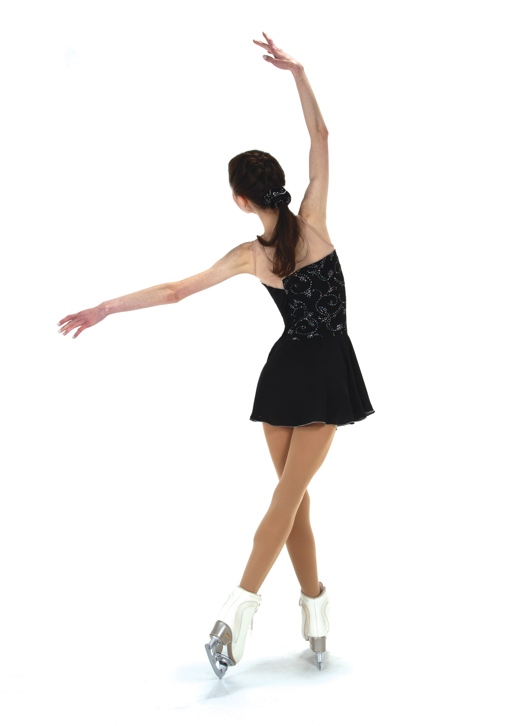 Skater in JR521 black On the Edge dress performing on ice, featuring glitter swirl lycra and flared georgette skirt for graceful motion.