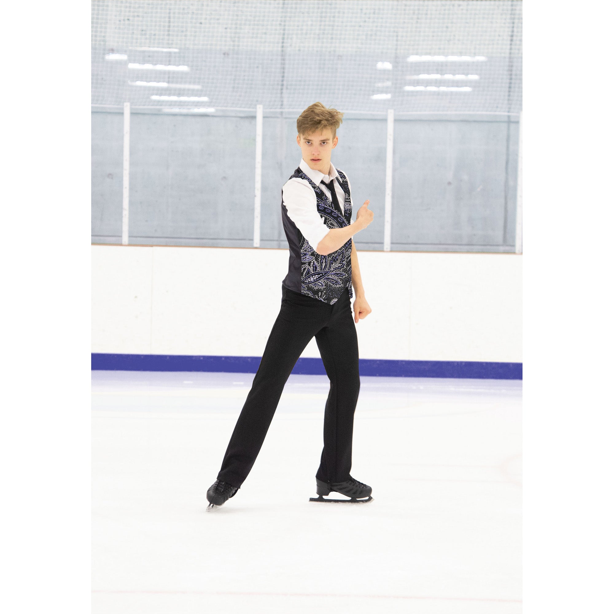 Figure skater wearing JR828 Mens Paisley Brocade Vest on ice, showcasing activewear for men's competition and dance performances.