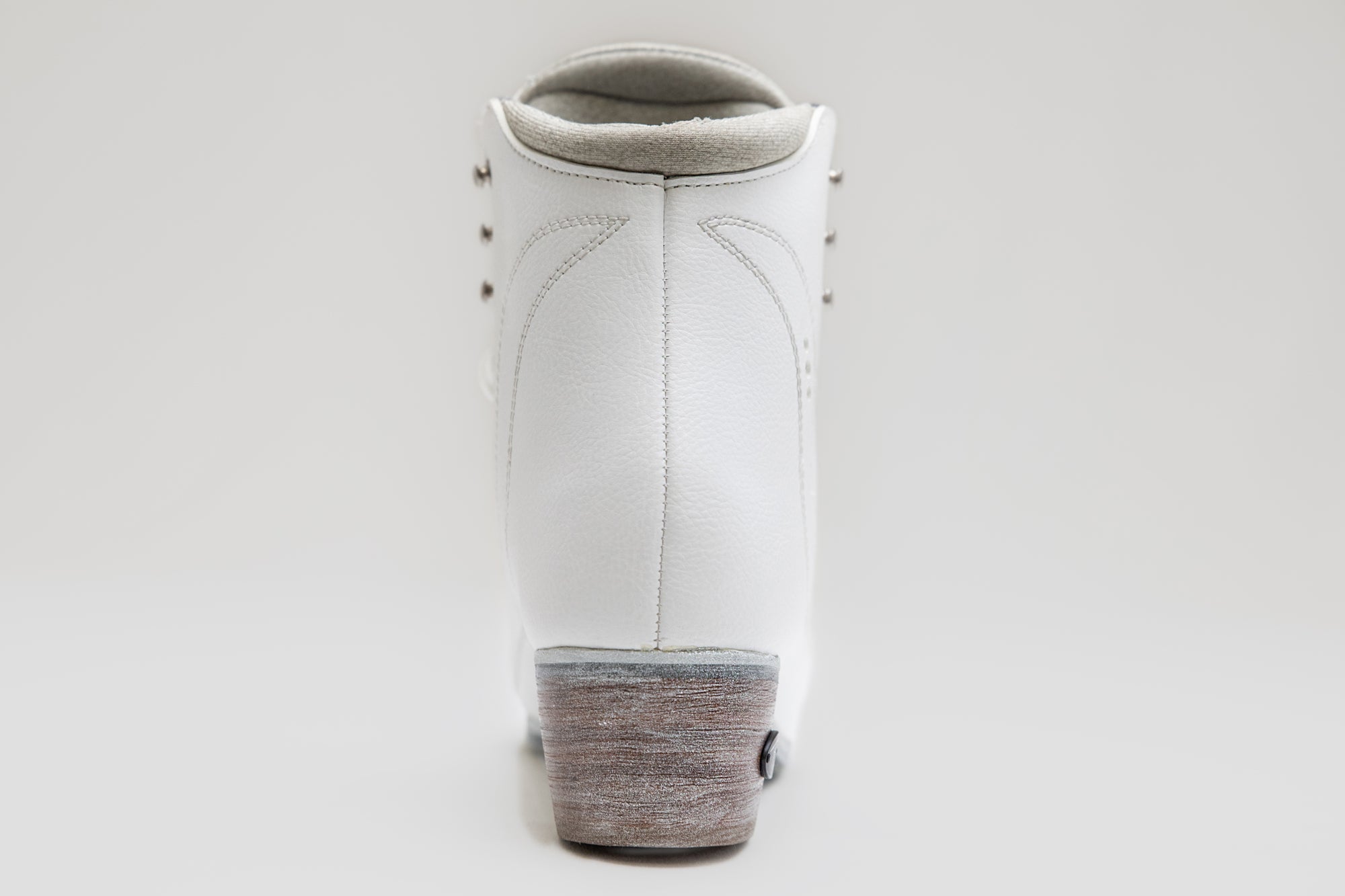Rear view of Riedell Vega womens figure skate boot highlighting padded collar and durable heel construction for skating performance.