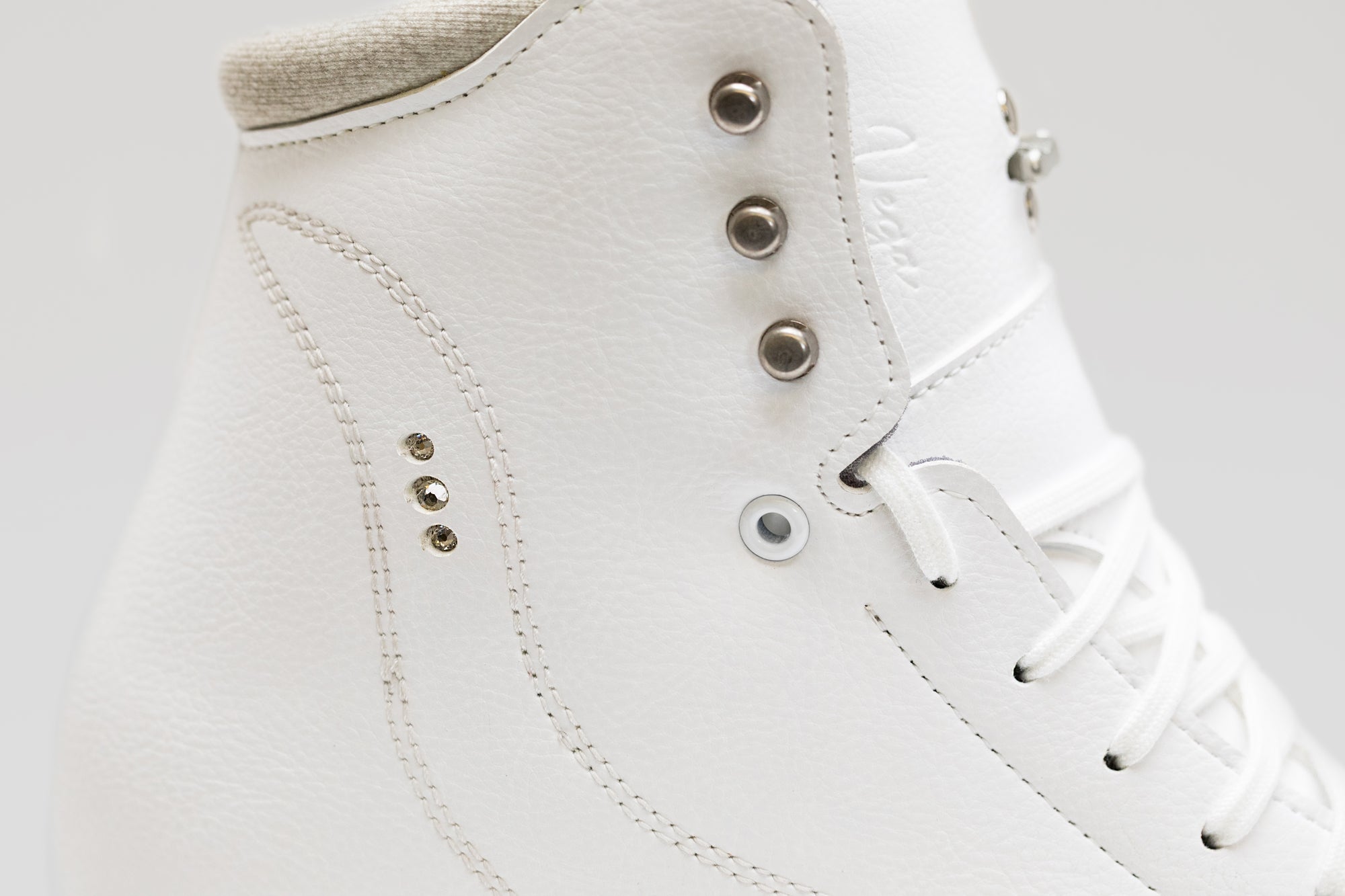 Detailed side close-up of Riedell Vega womens figure skate boot showing textured leather and precision eyelets for durability.