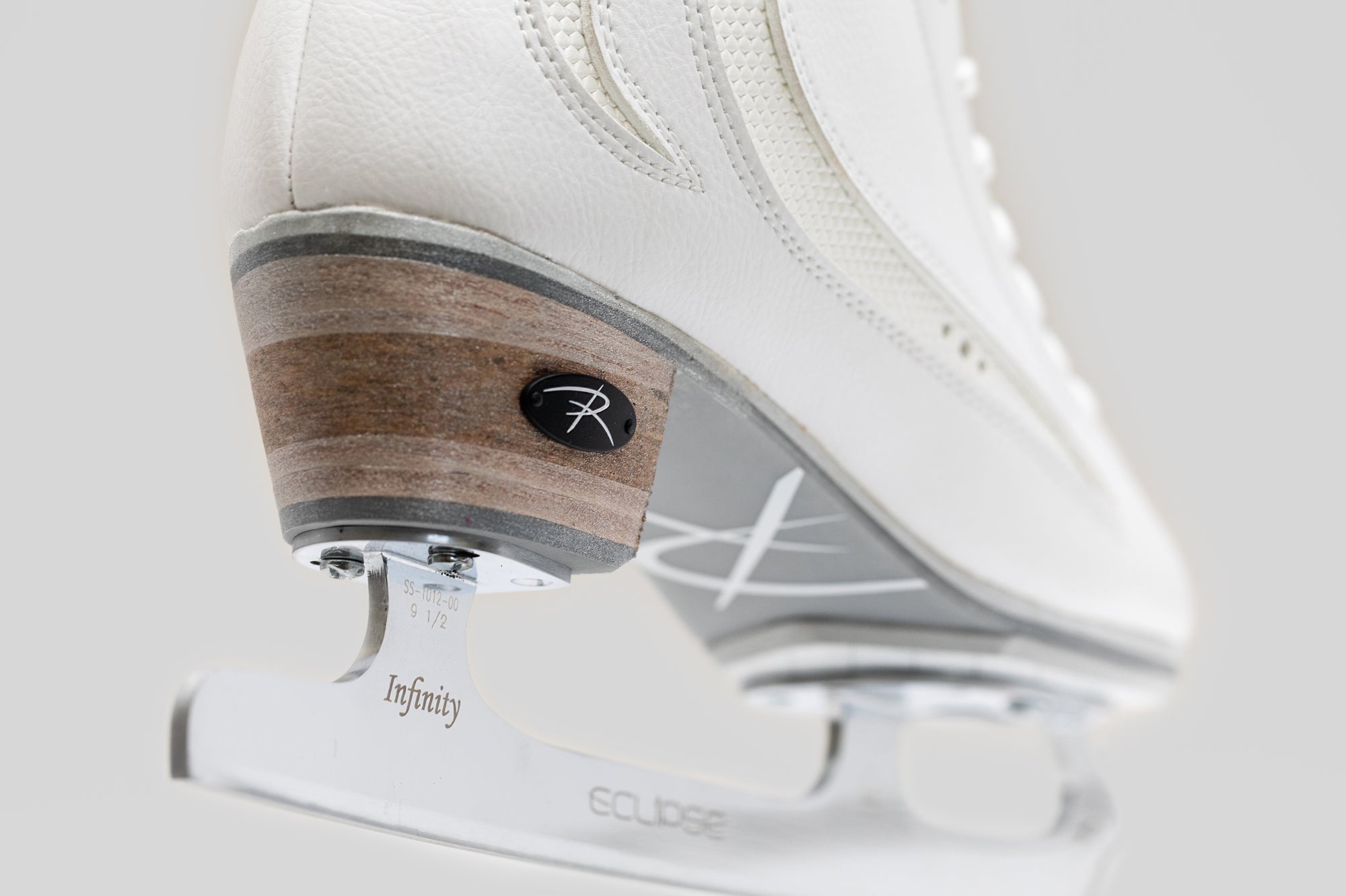 Close-up of Riedell Elara womens figure skate boots showing Eclipse Infinity blade and wooden heel, built for elite skating performance.