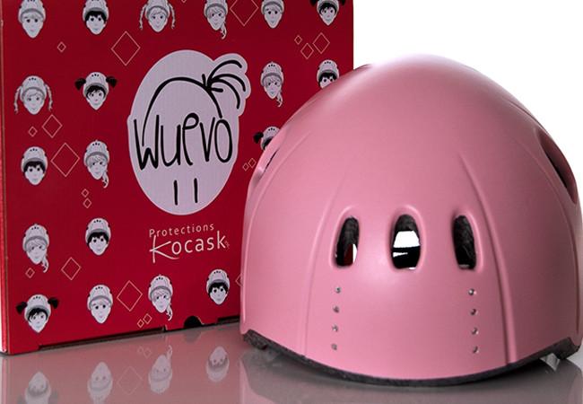 Pink Wuevo Ice Skating Helmet displayed next to branded packaging, highlighting stylish design and protective features for skaters.