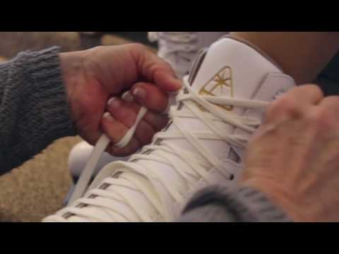 Hands tightening laces on a Jackson Ultima skate during a professional figure skate fitting session for personalized comfort and support.