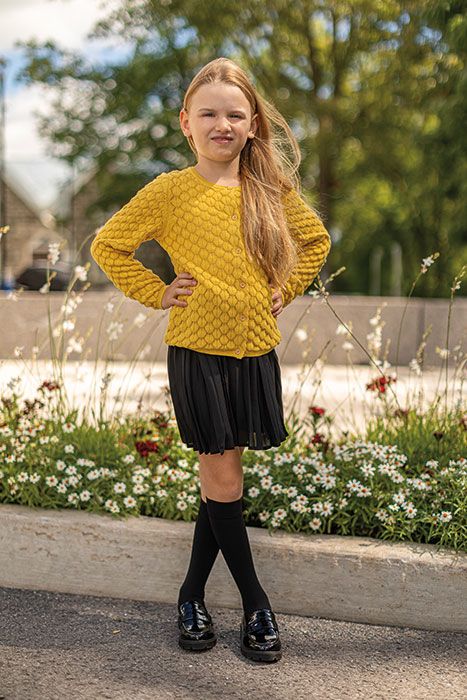 Girl in yellow sweater with black knee-high socks