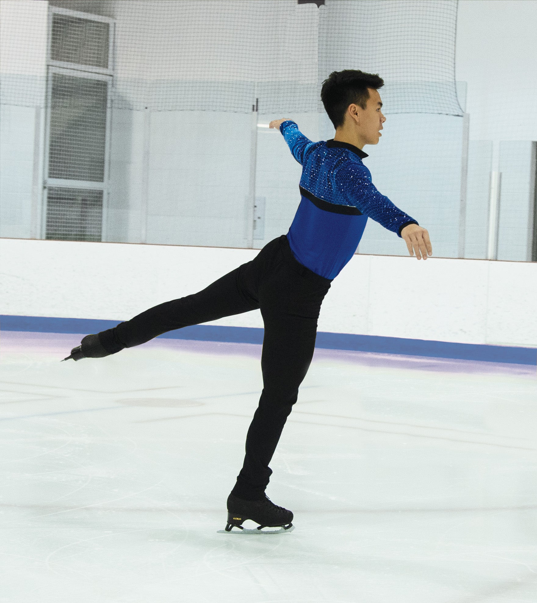 Skater in JR826 blue shirt with silver shimmer, performing on ice