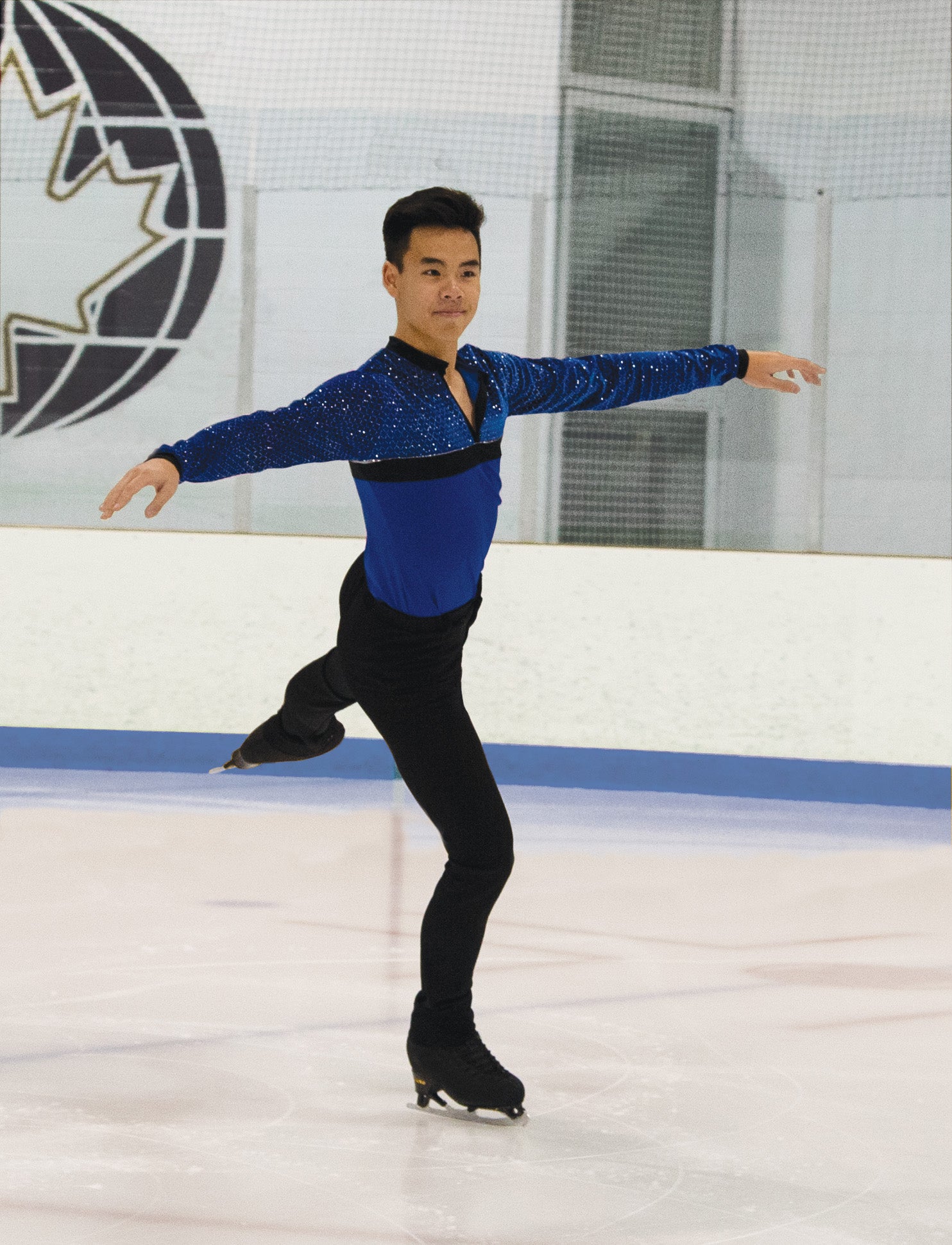 Figure skater wearing JR826 blue shirt, elegant pose on ice